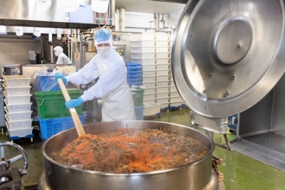 大釜での大量調理。一度に数千人分の量を、均一の味と品質に仕上げるよう配慮しながら作業します。